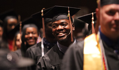 group of Purdue Global graduates in caps and gowns at graduation