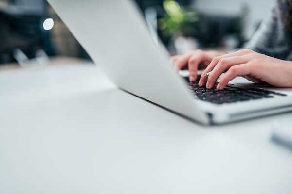 Lawyer's hands typing on laptop keyboard.