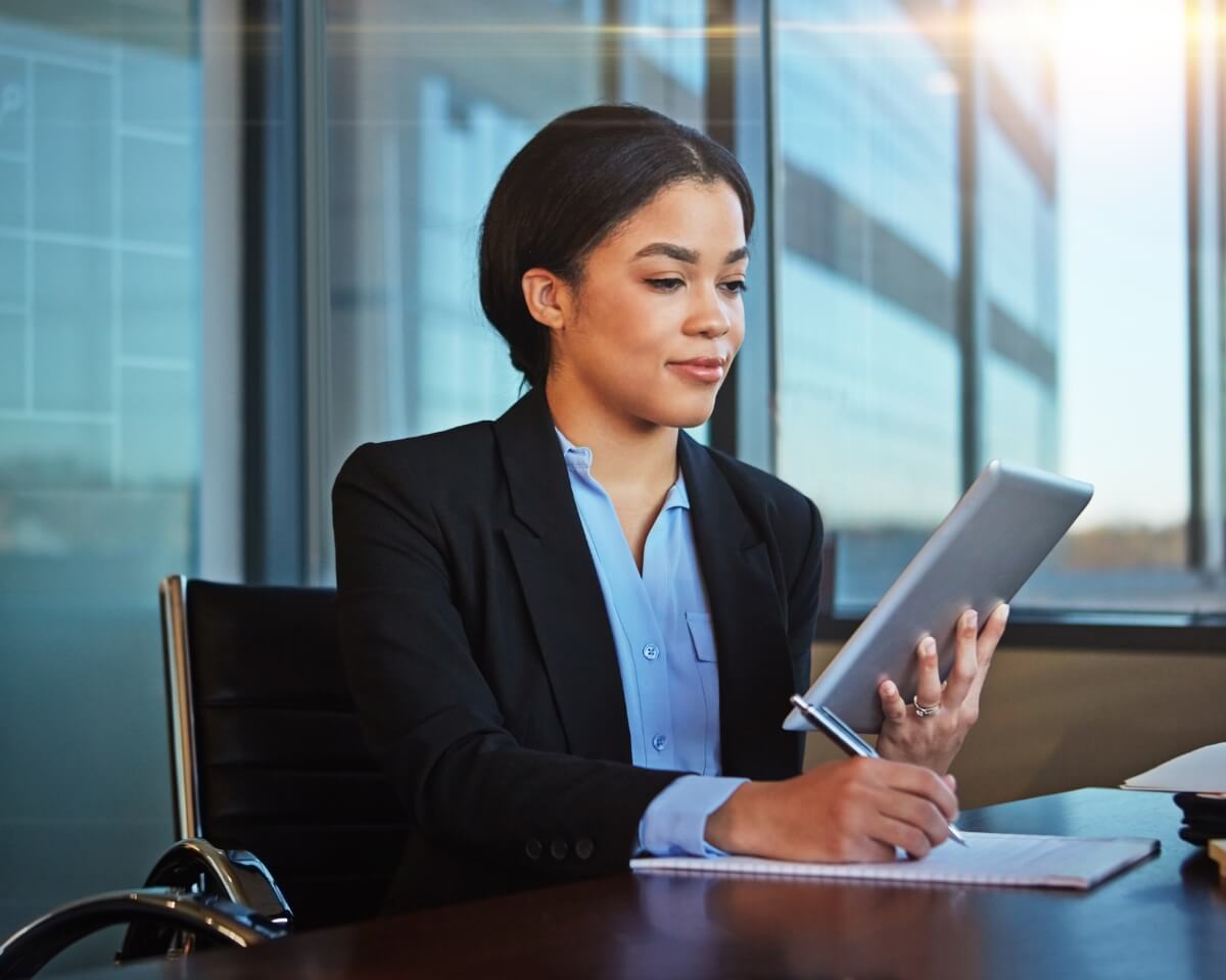 Legal support professional taking notes and holding a tablet