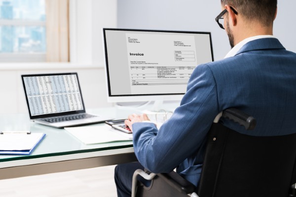 Man sitting at desk looking at laptop