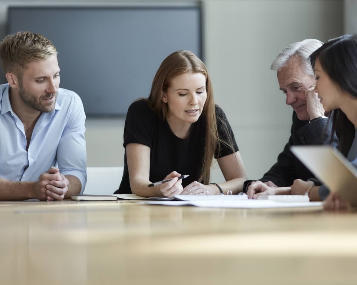 professionals collaborating on documents at a conference table