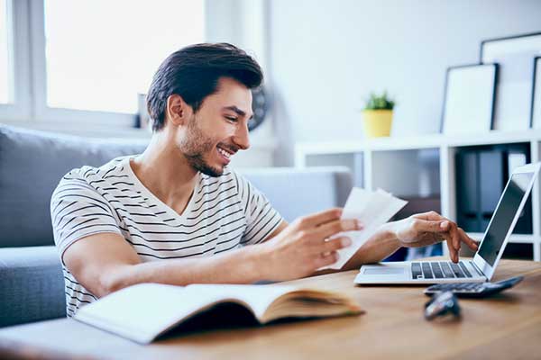 A man looks at a laptop on a desk