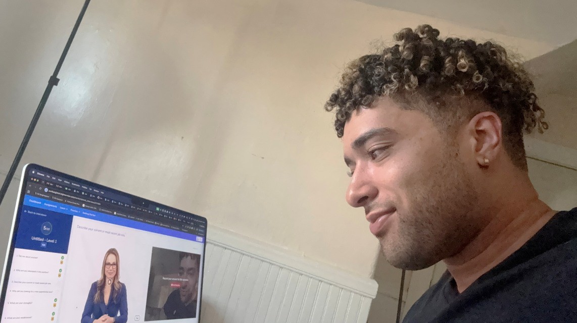 Cap: Christopher Fontes uses an AI-powered interview tool to prepare for interviews. Purdue Global’s Center for Career Advancement provides access to two platforms to help students and alumni practice interview techniques. (Photo provided)
Alt: A man watching a video on a laptop. 