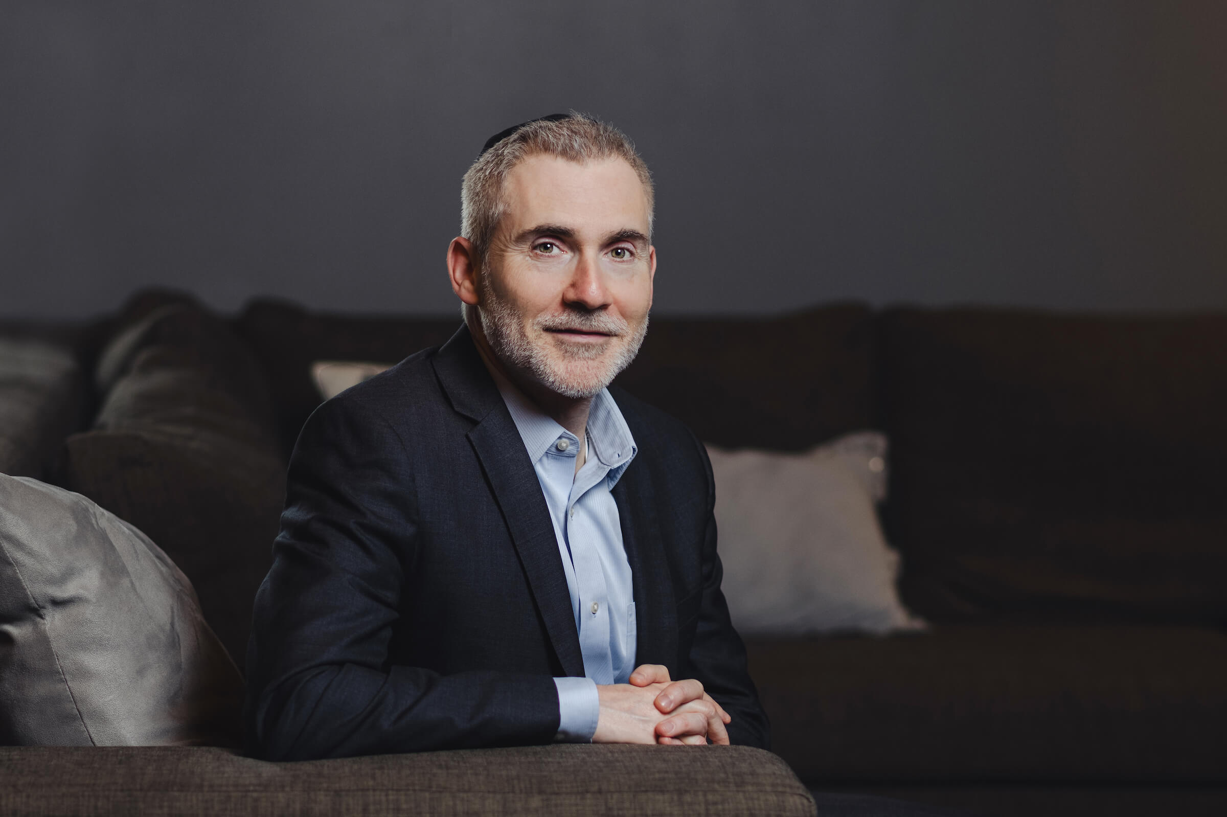 Martin Pritikin sitting on a black sofa.