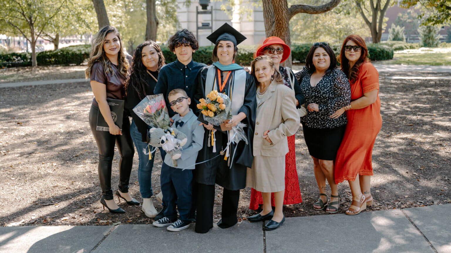 In a poignant family moment, immediately after her graduation ceremony, Yvette Martinez poses outside with family. Her two sons were present and some of her family members traveled from as far as California to share this important experience with her. (Purdue Global photo/Kelsey Lefever)