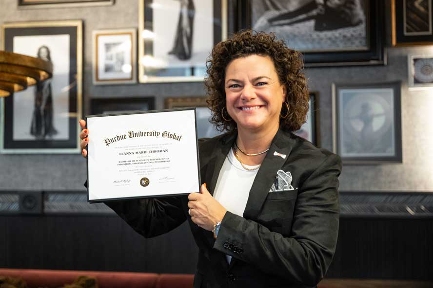 Leanna Chroman, in a white shirt and black blazer, stands in front of one of her restaurants, 1933 Lounge in Carmel, Indiana.