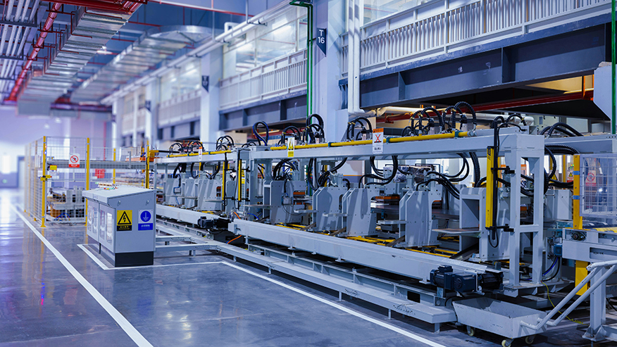 Modern automated manufacturing assembly line with robotic equipment and safety barriers in an industrial facility