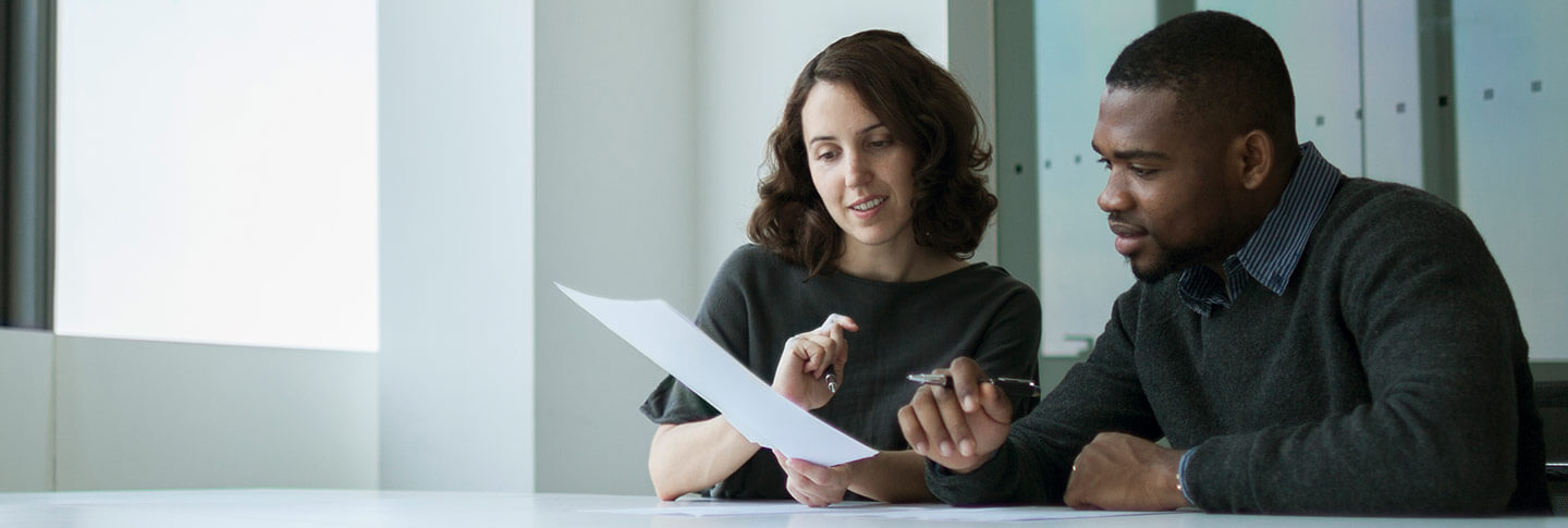 professionals discussing a document in a meeting room