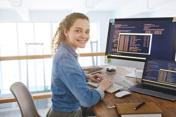 A woman works while sitting at a desk in front of a computer