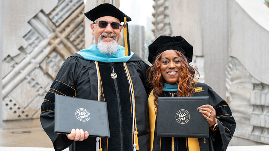 Purdue Global graduates Ted Lawrence and Dianna Pittman holding their diplomas