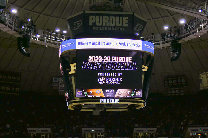 The scoreboard in Mackey Arena with the words "2023-24 Purdue basketball presented by Purdue Global"