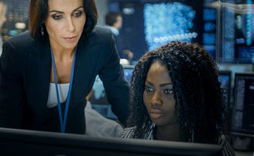 Two cybersecurity employees looking at something on a monitor