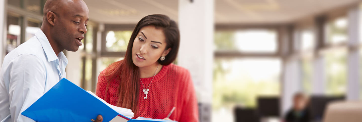teacher and student looking at notes in a binder