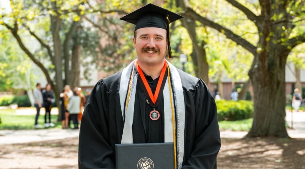 Purdue Global graduate Dillon Dunn in cap and gown