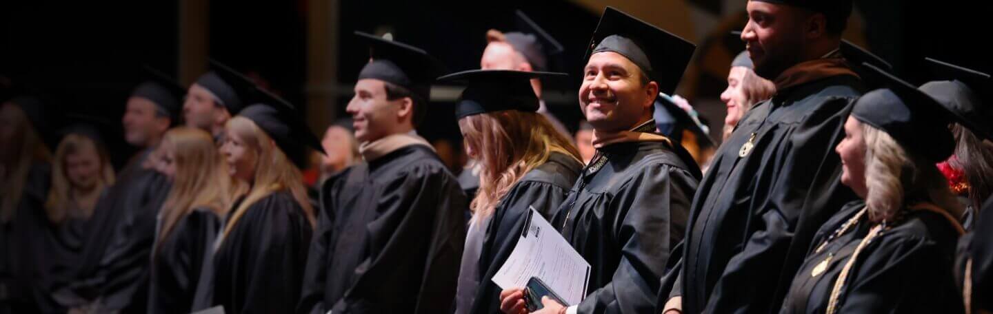 A group of Purdue Global graduates wearing caps and gowns.
