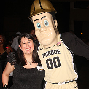 a Purdue Global graduate and Purdue mascot at the Black and Gold celebration