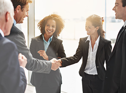 group of smiling lawyers shaking hands in an office