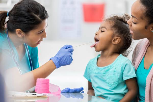 Urgent care nurse examines young patient.