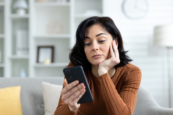 A woman procrastinates as she looks at her phone.