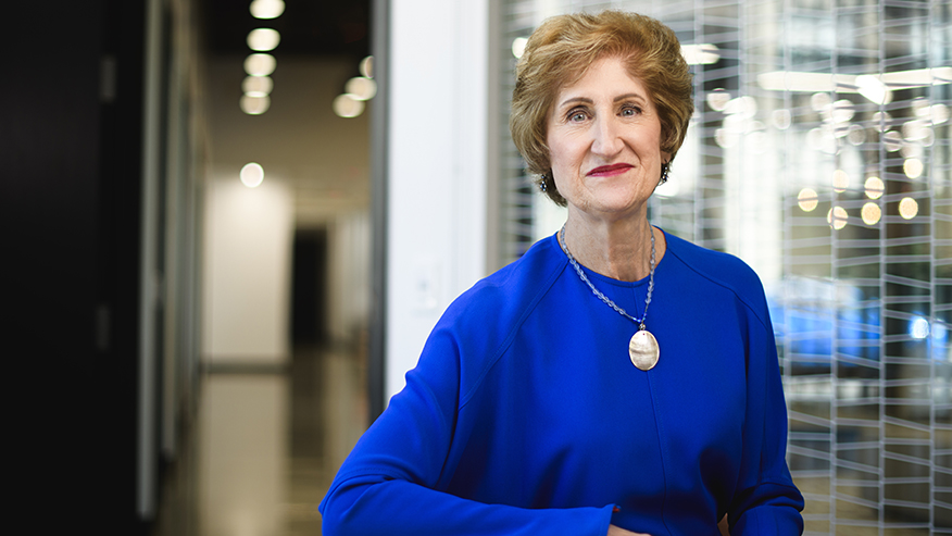 Carolyn Nordstrom wearing blue blouse standing in an office hallway