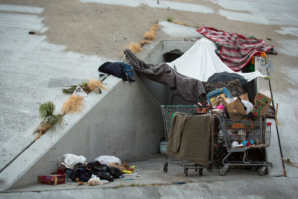 A makeshift shelter set up under a concrete overpass.