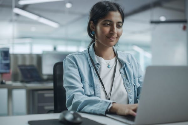 A junior software developer sits at a desk in an office