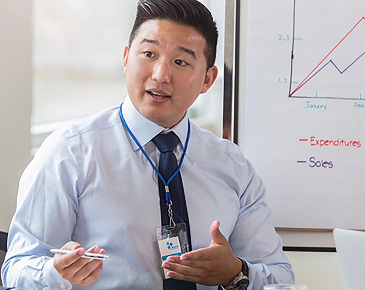 Business professionals discuss documents during a meeting in a bright conference room