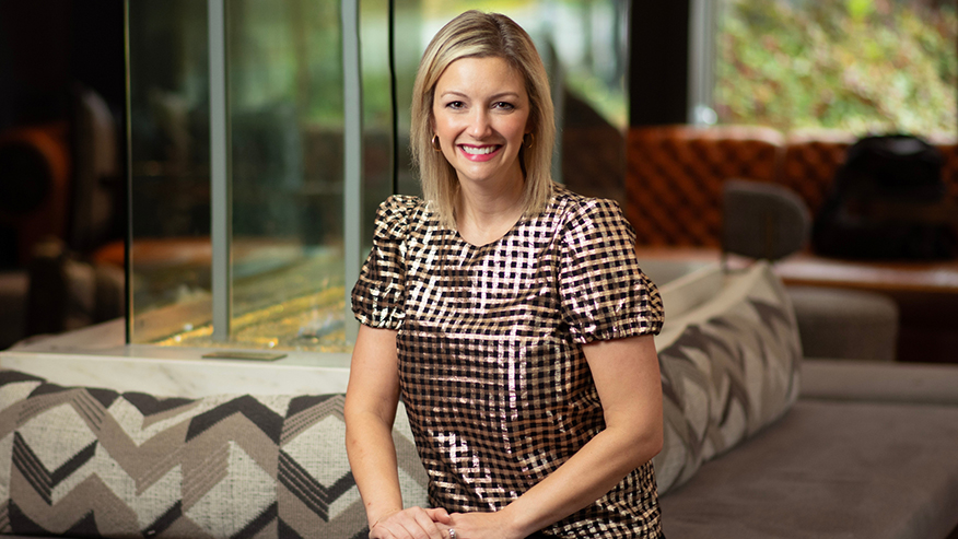 Amy Hawkinson sitting on a couch and smiling