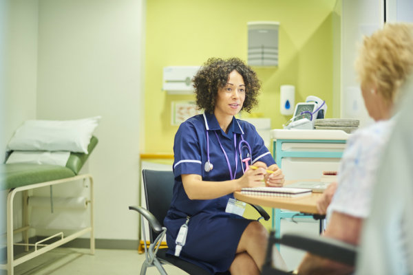 A nurse case manager speaks with a patient.