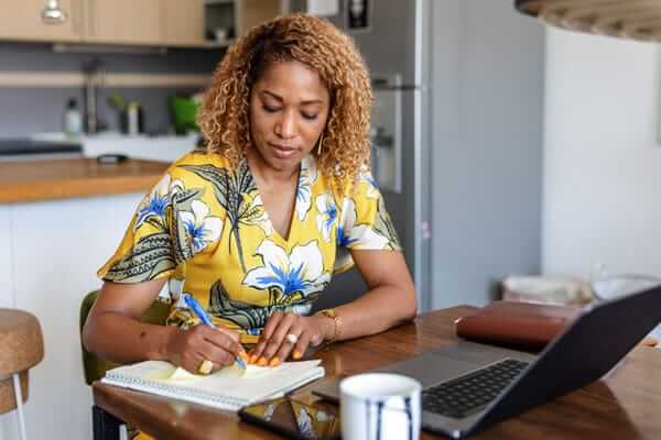 A woman writes in a notebook.