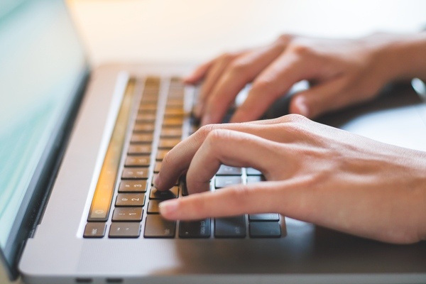 Image of a student's hands typing on a laptop.