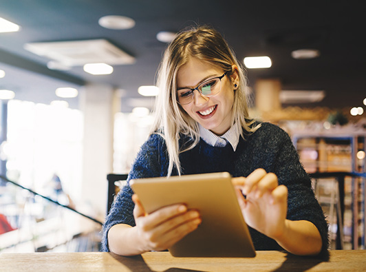 Woman studying on a tablet at the library.