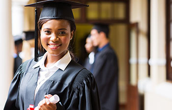 Woman graduate in cap and gown holding a diploma