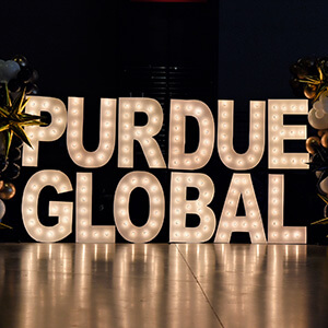 image of Purdue Global sign in lights with a black background