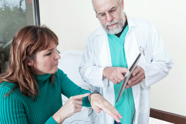 A doctor shows a patient how to use a health care app