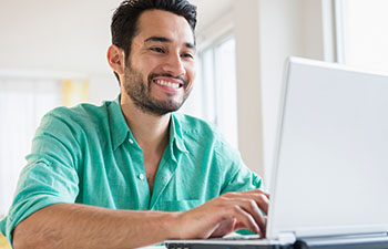 Man in green shirt working on laptop