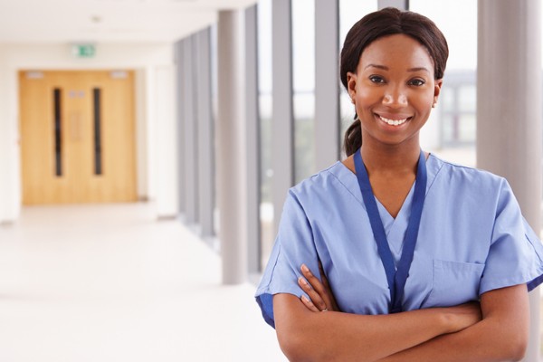 A nurse stands in a hospital corridor.