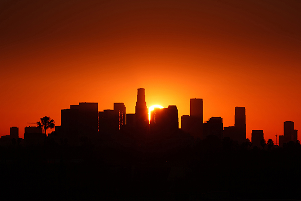 Sun setting behind a city skyline.