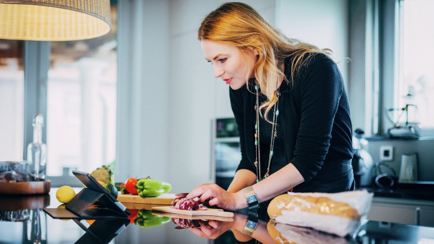 A woman following a recipe as she makes a healthy meal.