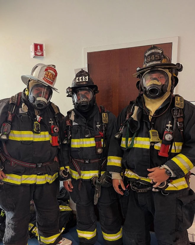 Dillon Dunn poses with fellow firefighters wearing their safety gear.