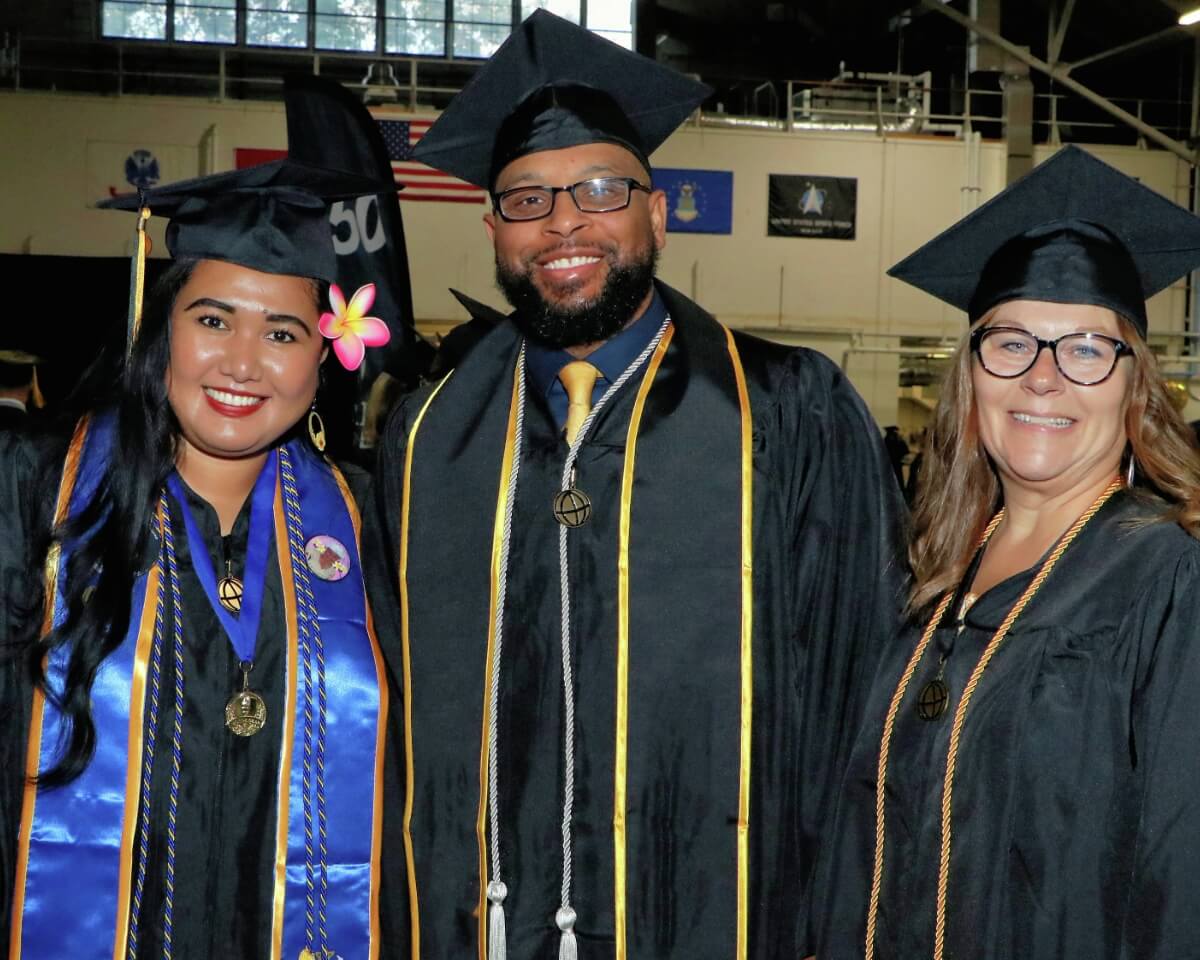 group of smiling Purdue Graduates in caps and gowns
