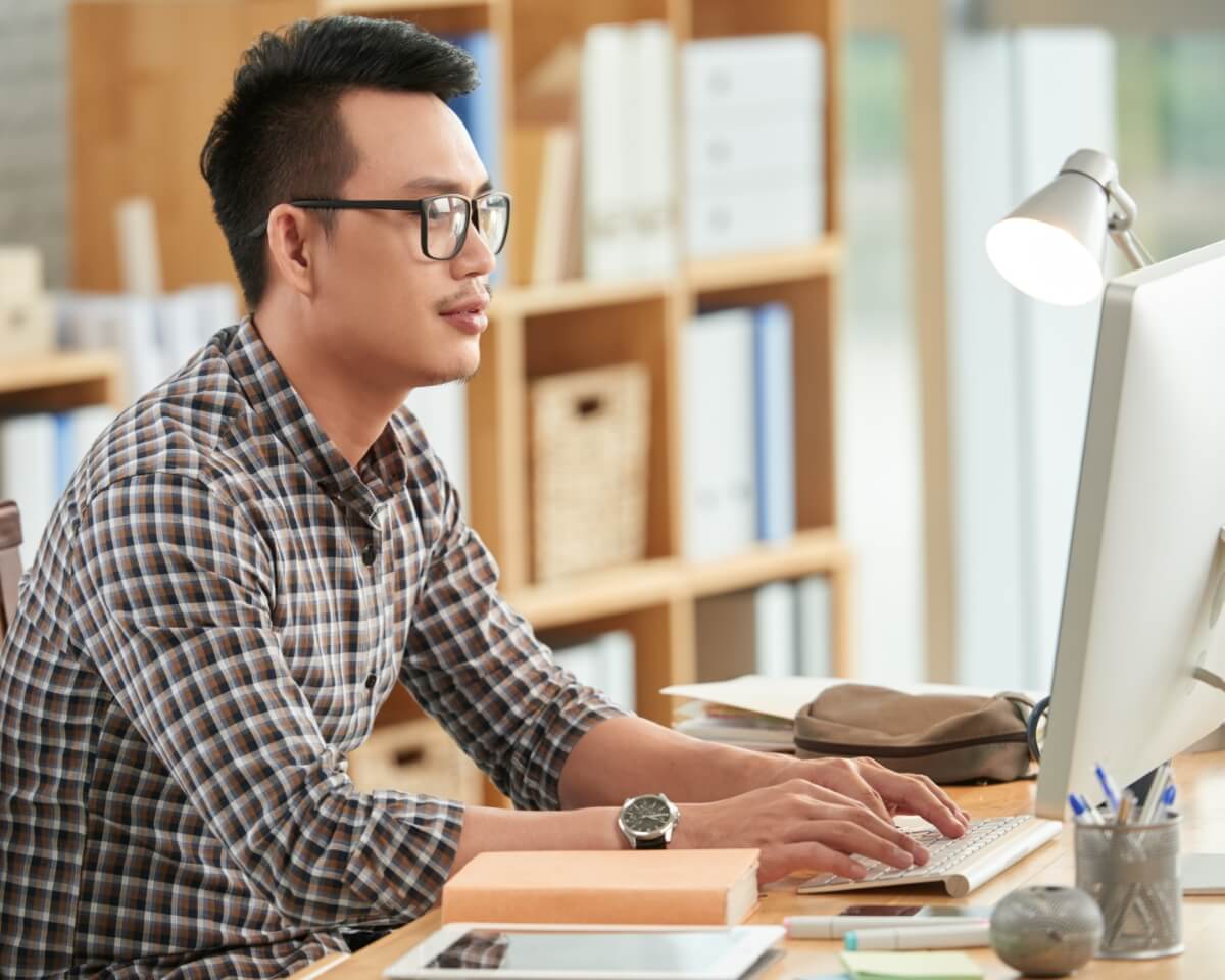 man working on a computer in a bright office