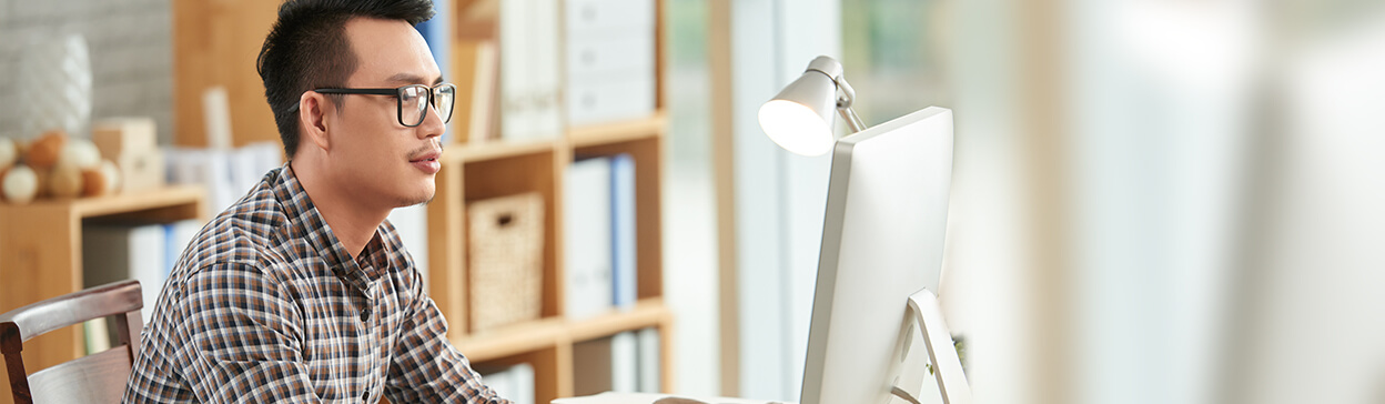man working on a computer in a bright office