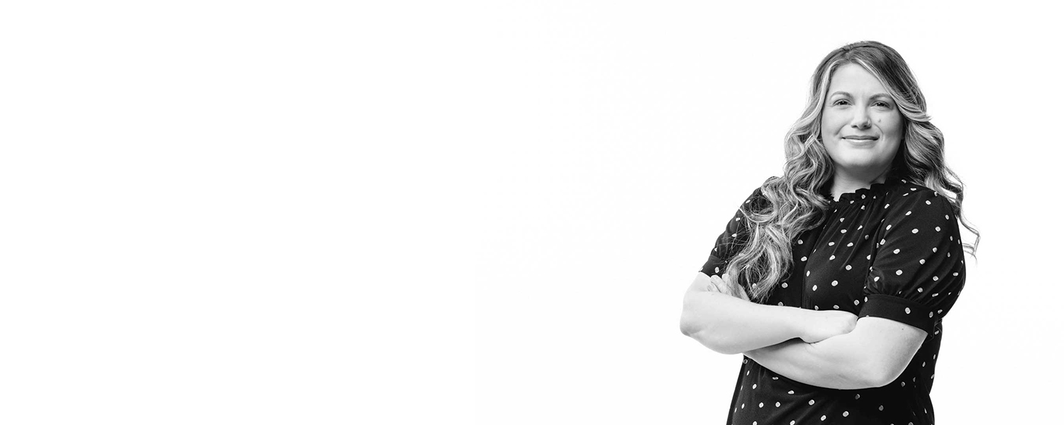 PG Student, Nichole, standing with arms crossed looking at the camera