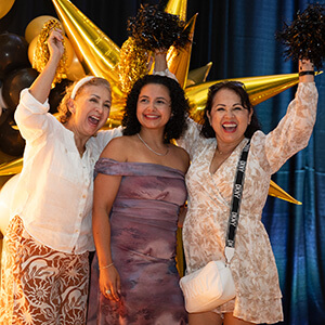 three smiling Purdue Global graduates at the Black and Gold Celebration