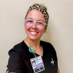 A woman in dark blue scrubs and a headband