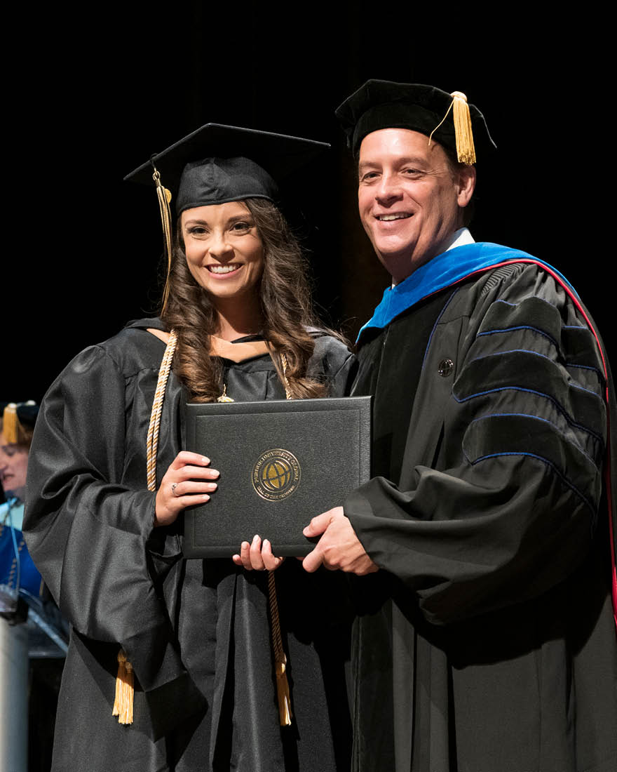 Bruso receives her diploma from the dean of Purdue Global’s School of Business, Jeffrey Buck (Purdue University photo/Kelsey Lefever)