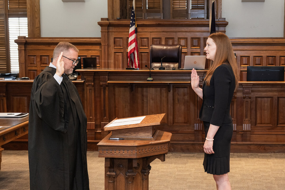 Lauren Mollon is sworn in by a judge in a courtroom.