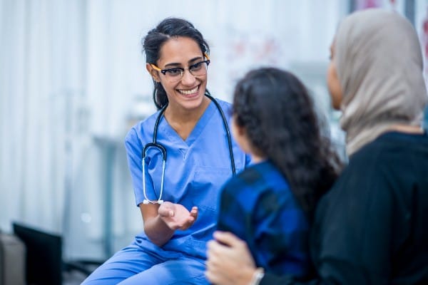 A family nurse practitioner talks with a patient.