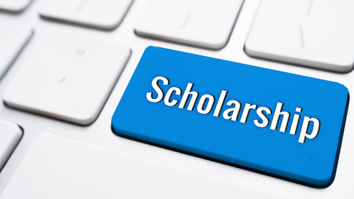 Blue “Scholarship” key on a white computer keyboard.